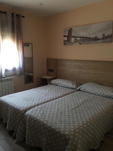 a bedroom with a bed with a white comforter at Casa Rural El Cabo in Carucedo