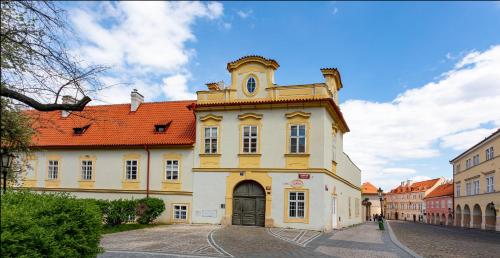 a large yellow building with a red roof at Loreta Hotel in Prague