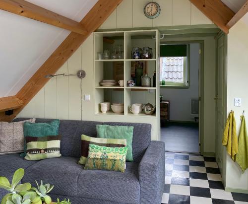 a living room with a couch and a clock at Apartment In de Wolken in Oostwoud