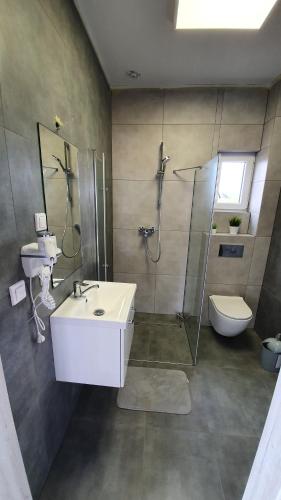 a bathroom with a sink and a shower and a toilet at Gąski Dom 100m2 3 sypialnie 2 łazienki 800 m do morza in Gąski