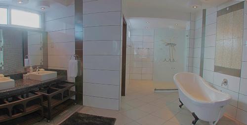a large bathroom with a tub and a sink at Cowrie Shell Beach Apartments Official in Bamburi