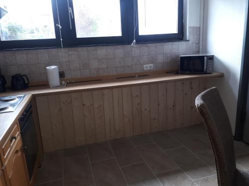 a kitchen with a counter with a microwave and two windows at Monteurunterkunft Oberaula in Oberaula