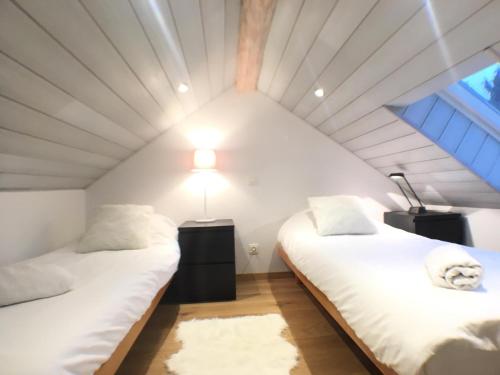 2 camas en una habitación con techo en B&B Pegasus II - Chambre de luxe avec sauna privatif, en Vielsalm