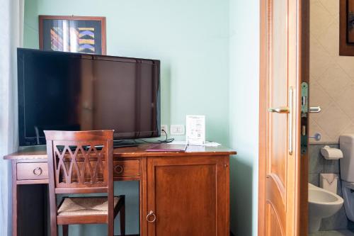 une télévision installée au-dessus d'un bureau en bois dans l'établissement Principato Di Ariis, à Rivignano