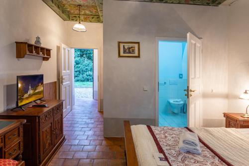 a bedroom with a bed and a bathroom with a toilet at Loreta Hotel in Prague