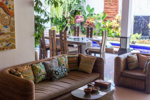 a living room with a couch and a table at MasBro ART Villas in Seminyak