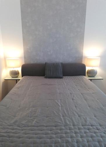 a bed in a room with two lamps on two tables at INSIDER Appartement in Schönwald