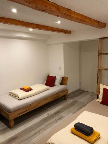 two beds in a room with red and yellow towels at Dionysos Traube in Rottweil