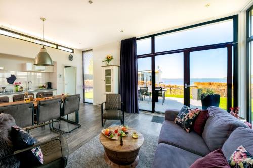 a living room with a couch and a table at Cube of Luxury direkt am Strand EuroParcs Bad Hoophuizen in Hulshorst