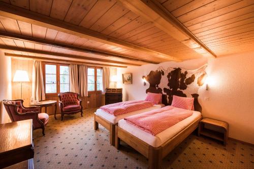 a bedroom with two beds in a room at Hotel Brienzerburli in Brienz