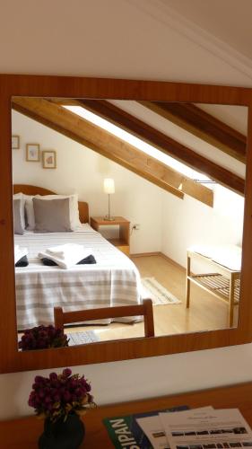 a reflection of a bedroom with a bed in a mirror at Eco Apartments Kate in Suđurađ