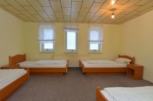 a room with three beds and two windows at Monteurhaus-Arbeiterunterkunft Haus Markus Suhl in Suhl