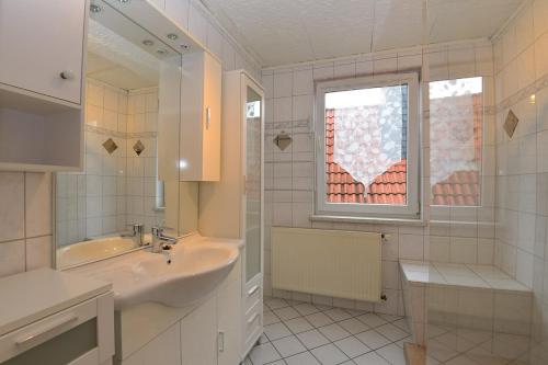 baño blanco con lavabo y ventana en Monteurhaus-Arbeiterunterkunft Haus Markus Suhl, en Suhl