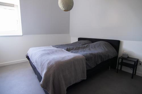 a bedroom with a bed with a blanket on it at Vissershuisje aan de waddenzee in Paesens