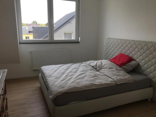 a bedroom with a bed with a red pillow on it at Apartment Brander Blick in Aachen