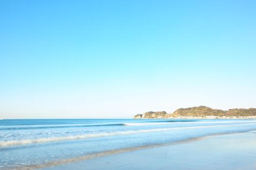 a beach with the ocean in the background at zaimokuza seasons in Kamakura