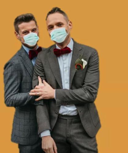 two men wearing face masks standing next to each other at Hôtel Le Cro-Magnon in Les Eyzies-de-Tayac