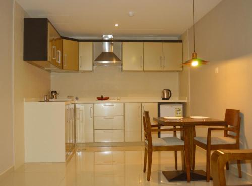 a kitchen with a table and chairs and a refrigerator at Yara Suites in Buraydah