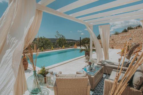 a patio with a pool and a table and chairs at The Residence in Šibenik