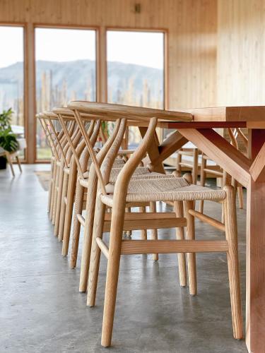 a row of wooden tables and chairs in a room at AKA Patagonia in Puerto Natales
