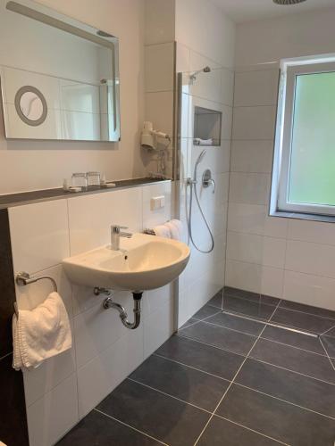 a bathroom with a sink and a shower at Hotel Restaurant zur Post in Wuppertal