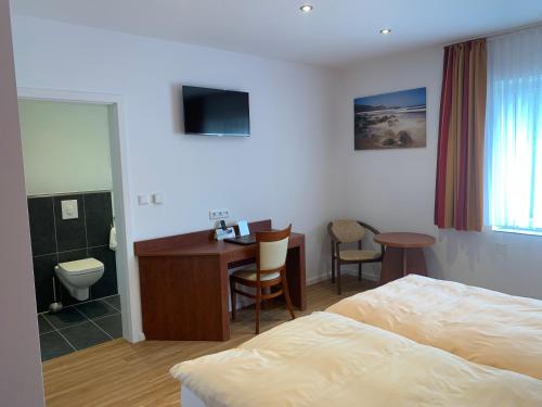 ein Hotelzimmer mit einem Bett, einem Schreibtisch und einem Bad in der Unterkunft Hotel Restaurant zur Post in Wuppertal