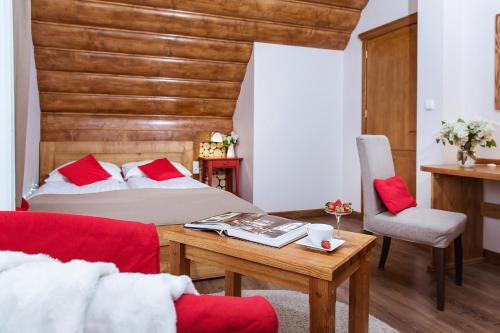 a bedroom with a bed and a table and a chair at Dom Wypoczynkowy Koliba in Białka Tatrzanska