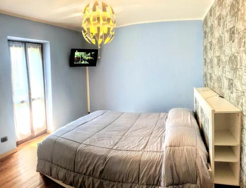 1 dormitorio con 1 cama y TV en la pared en B&B Casa Arcangeli, en Bracca