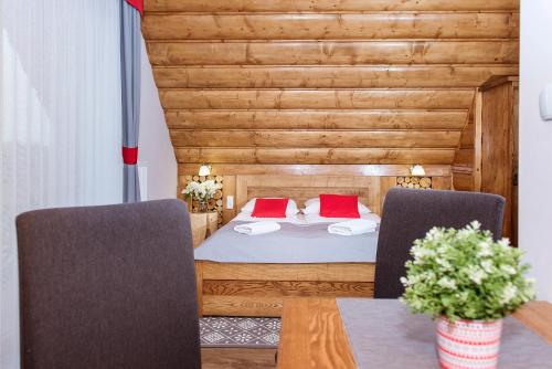 a bedroom with a bed and two chairs at Dom Wypoczynkowy Koliba in Białka Tatrzanska