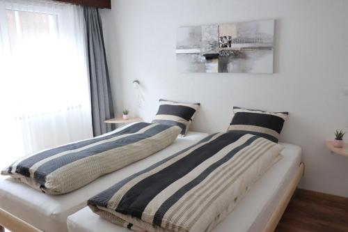 a bedroom with two beds with striped pillows at Ferienhaus Alea in Saas-Grund