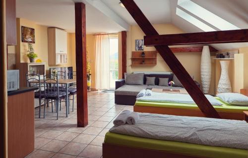 a room with two beds and a kitchen and a living room at Penzión Fox in Nemšová