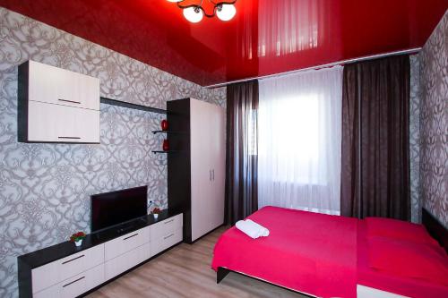スルグトにあるА. Усольцева д. 30 / 463のベッドルーム(赤いベッド1台、薄型テレビ付)
