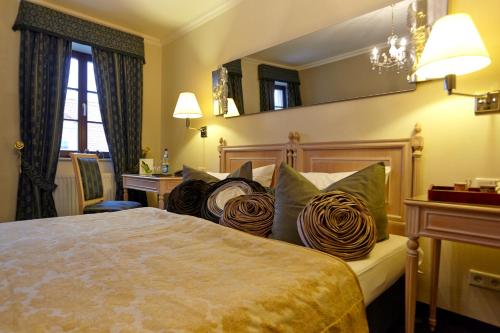 a hotel room with a bed with pillows on it at Sebnitzer Hof by STEIGER Hotels in Bad Schandau