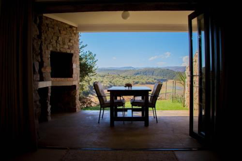 a table and chairs in a room with a view at African Safari Lodge in Grahamstown