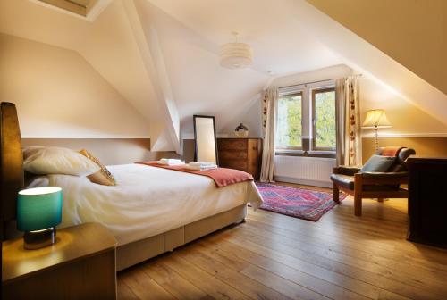 ein Schlafzimmer mit einem Bett, einem Stuhl und einem Fenster in der Unterkunft Glentruim Homestay B&B in Newtonmore