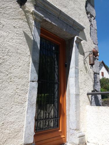 une porte avec un portail en fer sur le côté du bâtiment dans l'établissement Maison Bergoun, à Borce