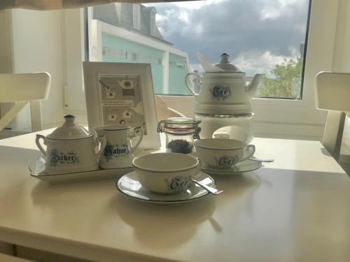 una mesa con dos tazas y un set de té. en Haus Meeresbrise Haus Karin, en Norderney