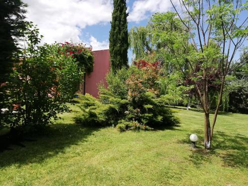 a yard with trees and a red house at Villa Gaia Trikala in Lygariá