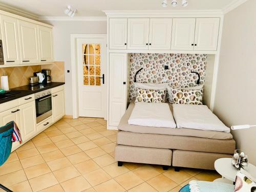 a small bedroom with a bed and a kitchen at Sellminchen Sylt in Westerland (Sylt)