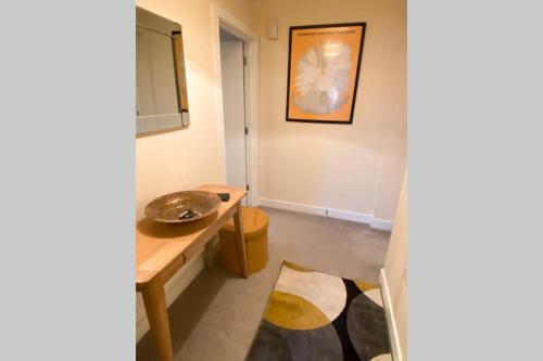 a room with a sink and a table with a mirror at 13 The Grosvenor, luxury flat, central Newmarket, in Newmarket