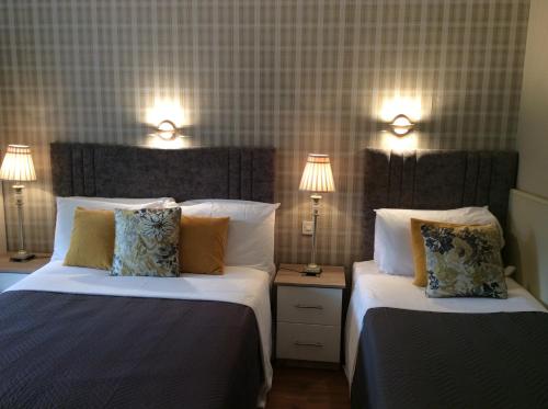 duas camas num quarto de hotel com duas lâmpadas em The Gardens B&B em Killarney