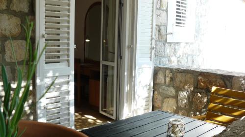 a wooden table sitting on a porch with a window at Eco Apartments Kate in Suđurađ