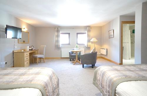a hotel room with two beds and a desk at Bannview Bed & Breakfast in Portadown