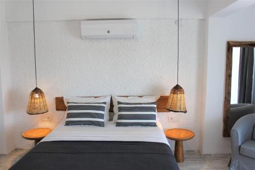 a bedroom with a bed with two pillows and two lights at Villamer Alaçatı in Alaçatı