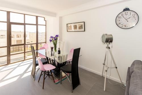 a dining room with a table and a clock on the wall at Guest H4U - Povoa seaside in Póvoa de Varzim