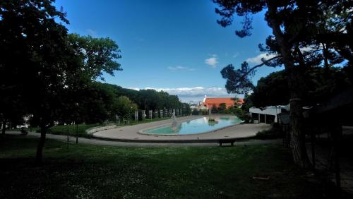 a fountain in a park with a bench in the grass at Alex Home in Lisbon