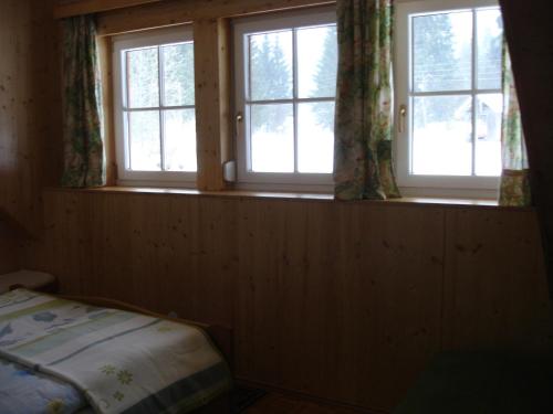 um quarto com 3 janelas e uma cama em Apartment Janschitz Gundersheim em Gundersheim