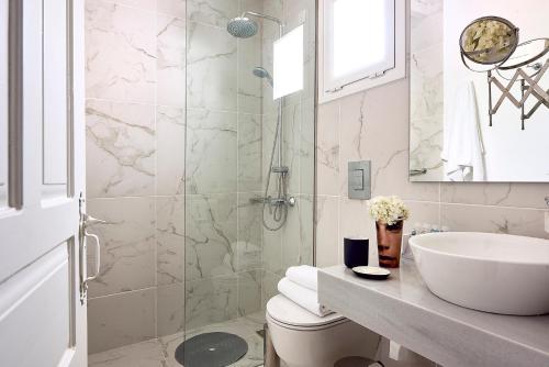 a bathroom with a sink and a toilet and a shower at Nakou Village in Koutsounari