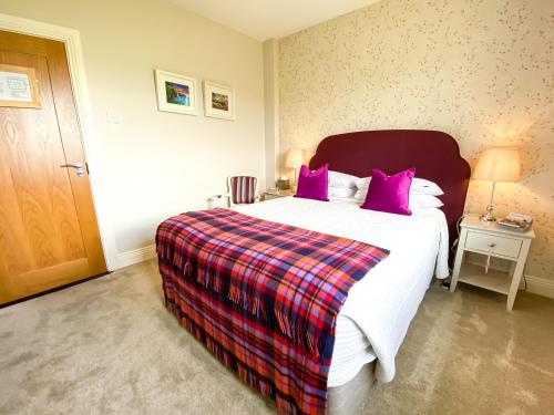 um quarto com uma cama grande e almofadas roxas em Daly's House em Doolin