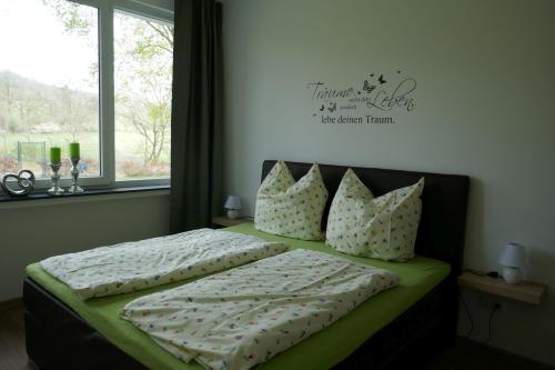 a bedroom with a bed with pillows and a window at Suite Am Radweg in Pittenbach
